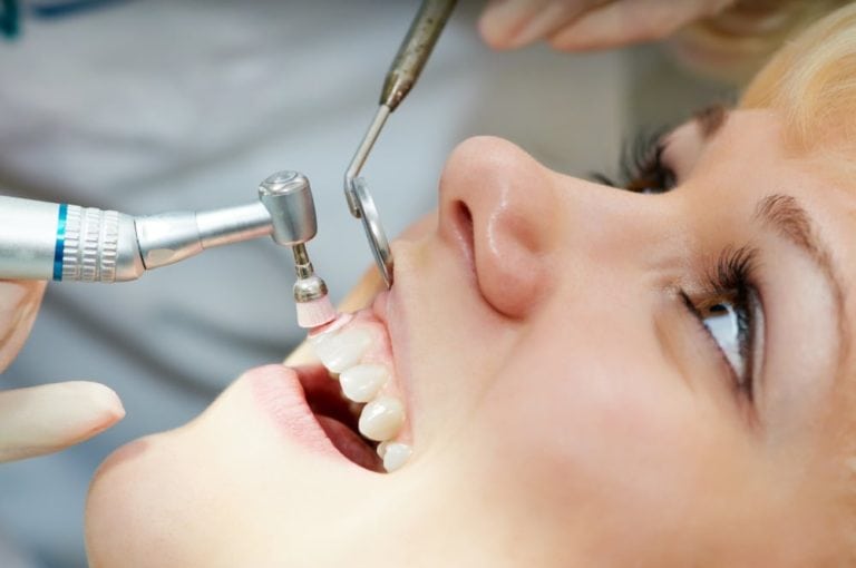 Image of female patient dentist cleaning her teeth