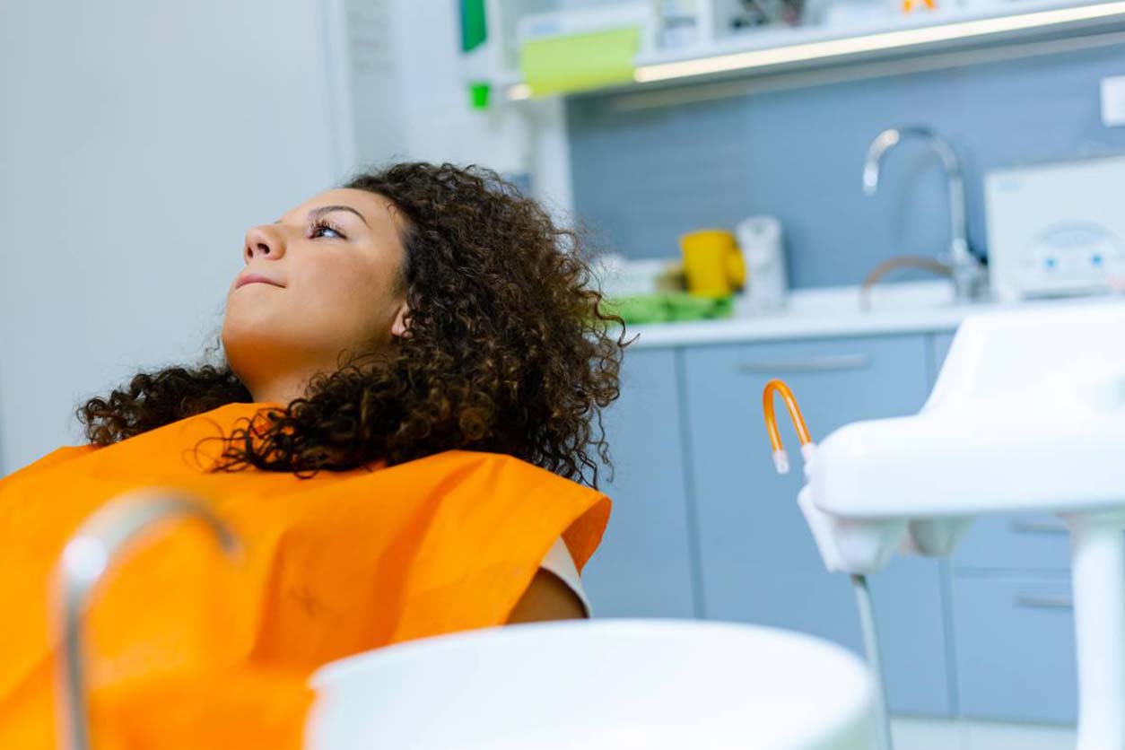 Young woman at the dentist feeling anxiety.