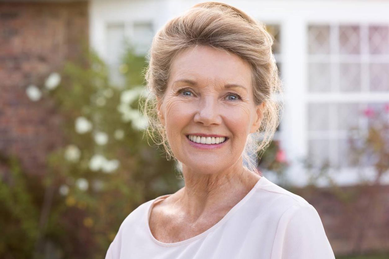 Smiling older woman living with dentures