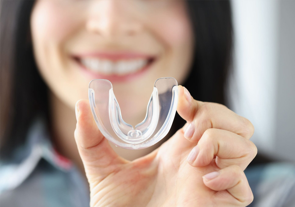 Stock image of a female dentist holding bite guard