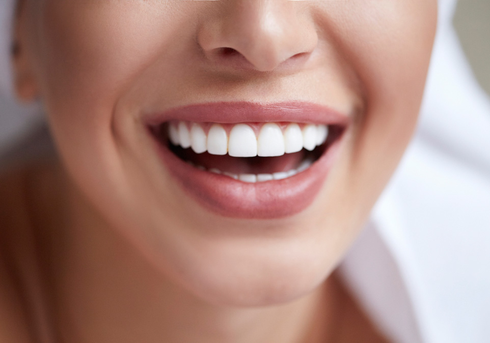 Stock image of a smiling female focusing on her teeth